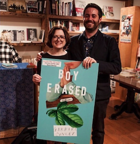 Maud Newton and Garrard Conley stand behind a large foamcore-backed poster of Conley's book, Boy Erased, at Book Court, after his book launch, in May 2016